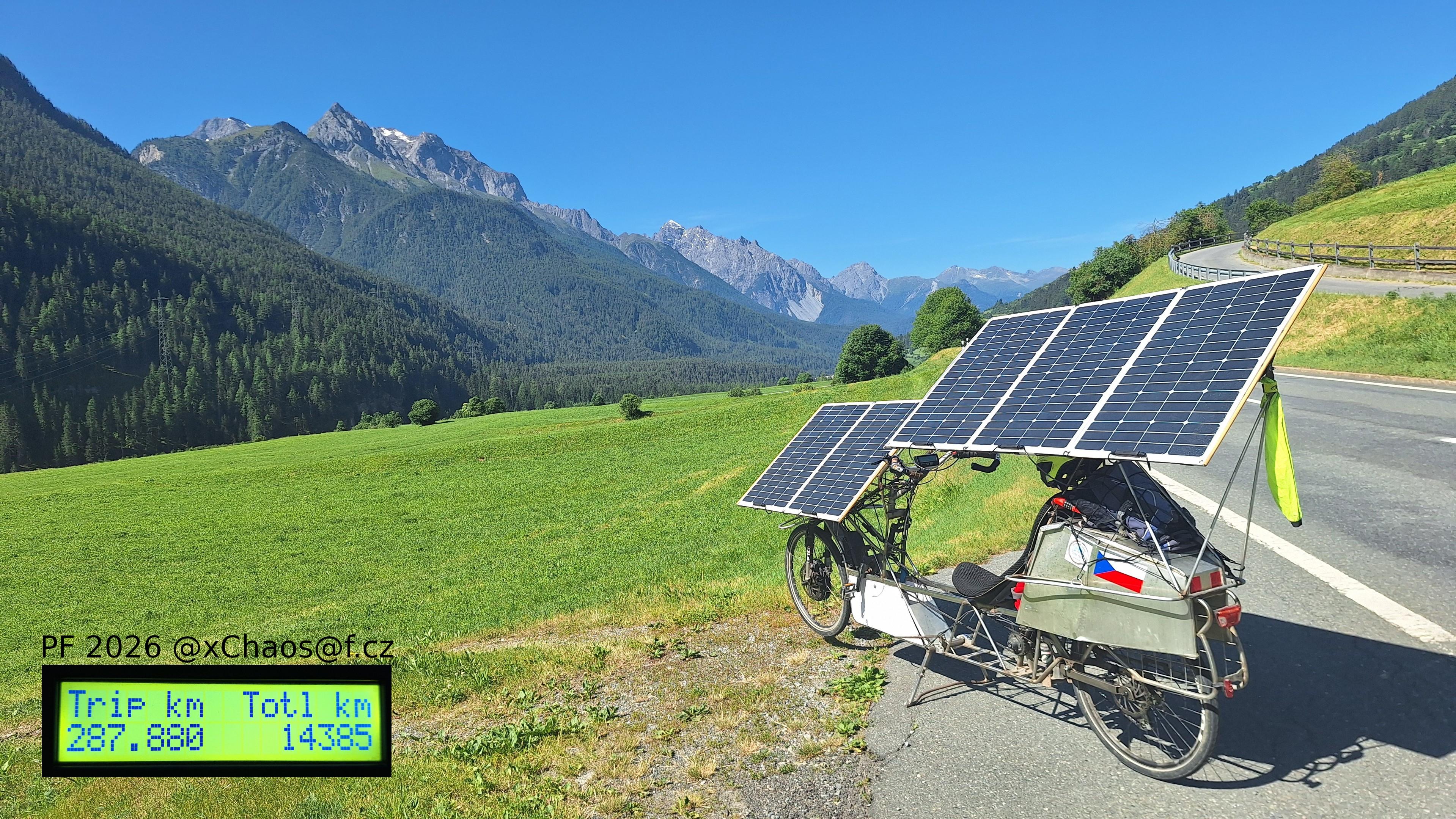 Solar bike parked in lower Engadin valley in Swiss Alps, with screenshot of cycleanalyst showing 287 km trip and PF 2026 message.