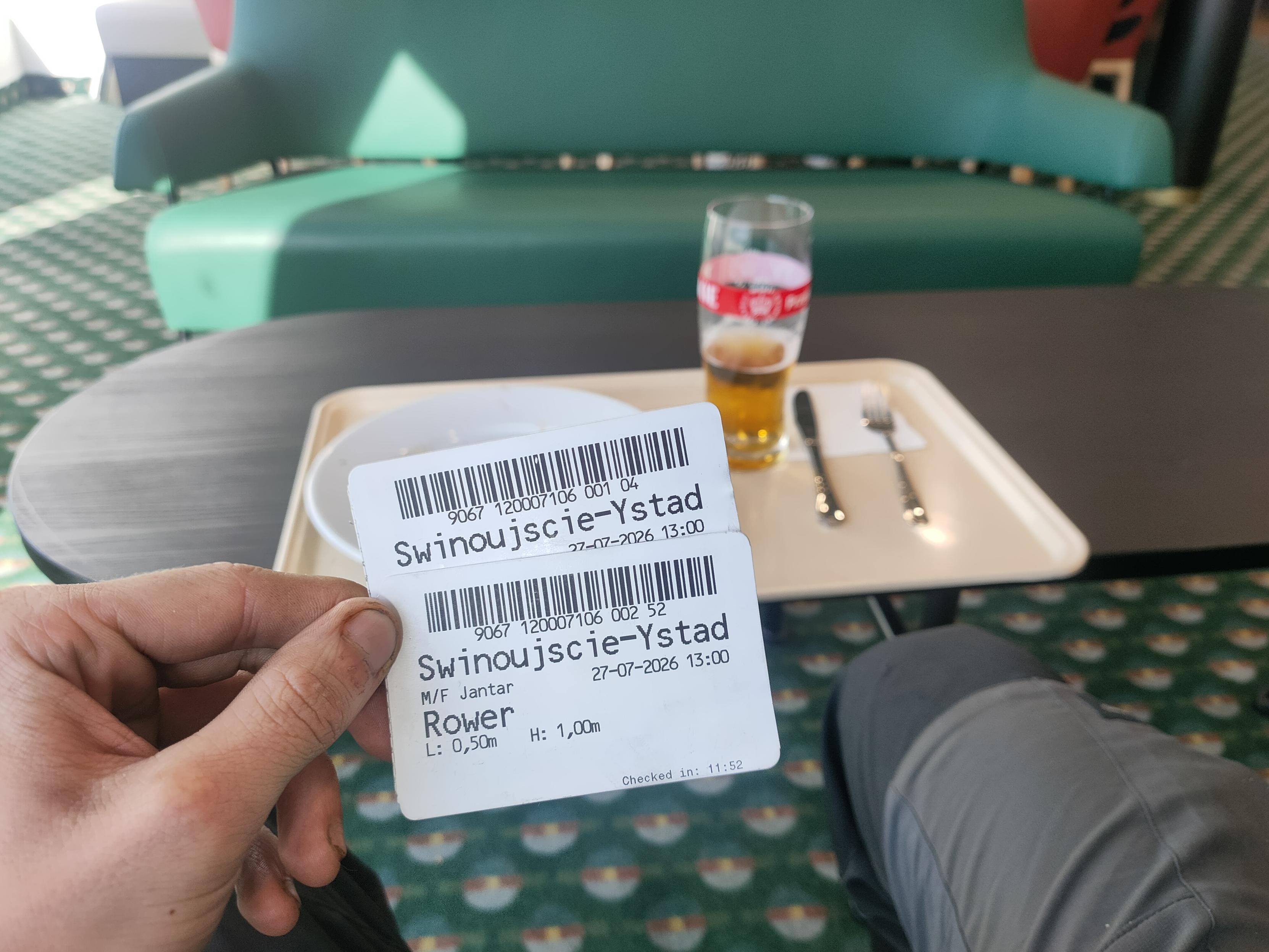Tickets for the ferry with eaten plate and half finished beer in the background.